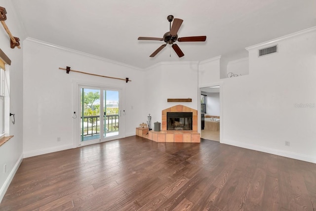 unfurnished living room with a tiled fireplace, a ceiling fan, wood finished floors, baseboards, and crown molding