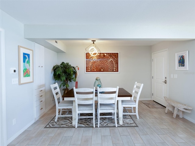 2400 N Beach Rd Unit 1, Englewood, FL 34223 - dining room featuring a chandelier, light wood-style floors, and baseboards