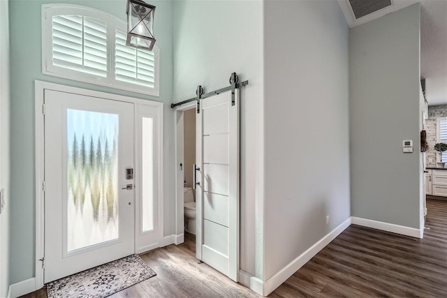 11367 Perico Isle Cir, Bradenton, FL 34209 - foyer featuring dark wood finished floors, a barn door, baseboards, and plenty of natural light