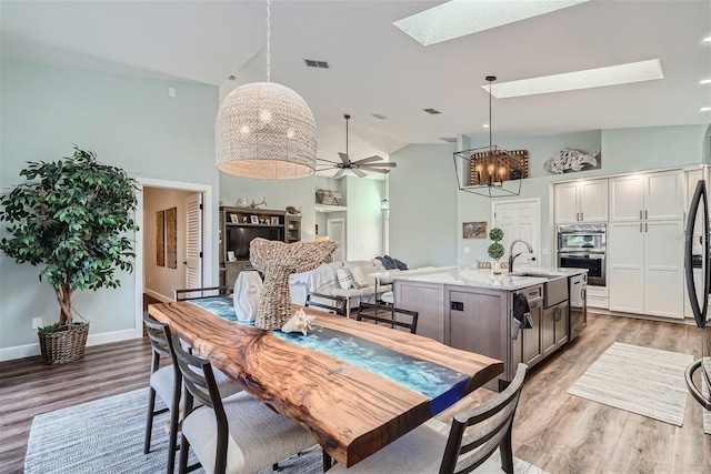 11367 Perico Isle Cir, Bradenton, FL 34209 - dining area with a skylight, light wood-style floors, a ceiling fan, high vaulted ceiling, and baseboards