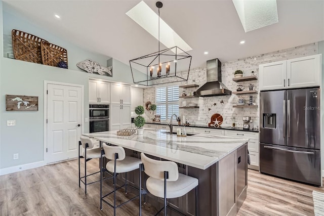 11367 Perico Isle Cir, Bradenton, FL 34209 - kitchen featuring appliances with stainless steel finishes, wall chimney range hood, open shelves, a sink, and backsplash