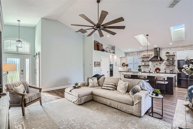 11367 Perico Isle Cir, Bradenton, FL 34209 - living room with high vaulted ceiling, light wood-type flooring, a skylight, and a ceiling fan