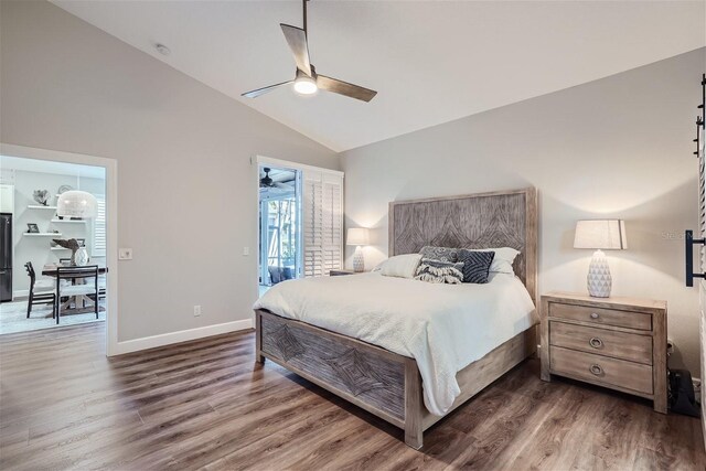 11367 Perico Isle Cir, Bradenton, FL 34209 - bedroom with lofted ceiling, wood finished floors, baseboards, a ceiling fan, and black fridge