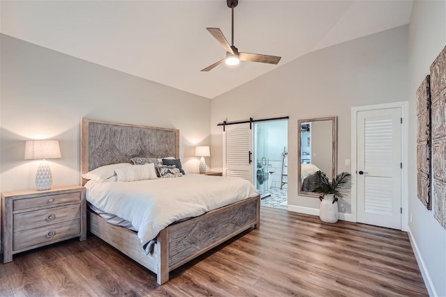 11367 Perico Isle Cir, Bradenton, FL 34209 - bedroom with wood finished floors, a barn door, baseboards, and high vaulted ceiling