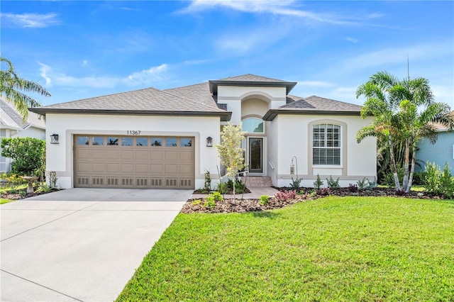 11367 Perico Isle Cir, Bradenton, FL 34209 - view of front of house featuring stucco siding, an attached garage, driveway, a front lawn, and a shingled roof