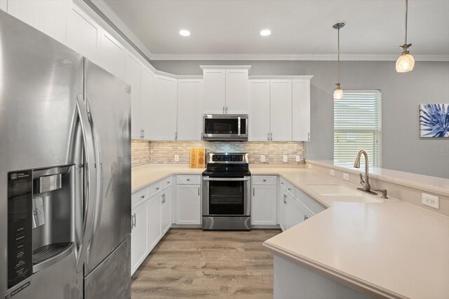 2808 124th Ave E, Parrish, FL 34219 - kitchen featuring stainless steel appliances, a peninsula, light wood-style flooring, ornamental molding, and decorative backsplash