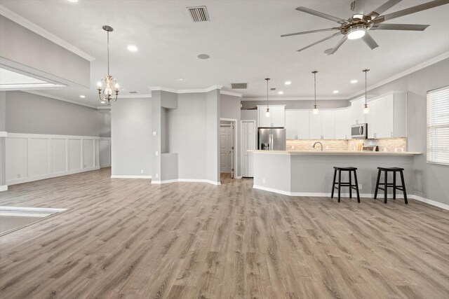 2808 124th Ave E, Parrish, FL 34219 - living area featuring ornamental molding, recessed lighting, light wood finished floors, a ceiling fan, and a chandelier