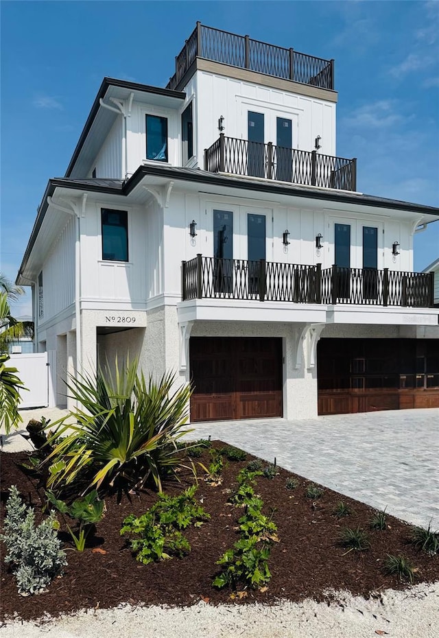 2809 Avenue Ave E, Holmes Beach, FL 34217 - coastal inspired home featuring a balcony, a garage, french doors, and decorative driveway