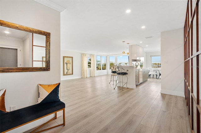 entrance foyer featuring light wood finished floors, ornamental molding, recessed lighting, and baseboards