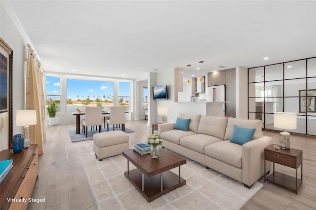 living room featuring light wood-type flooring, recessed lighting, and crown molding