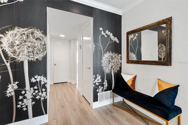 hall featuring wood finished floors, crown molding, and baseboards