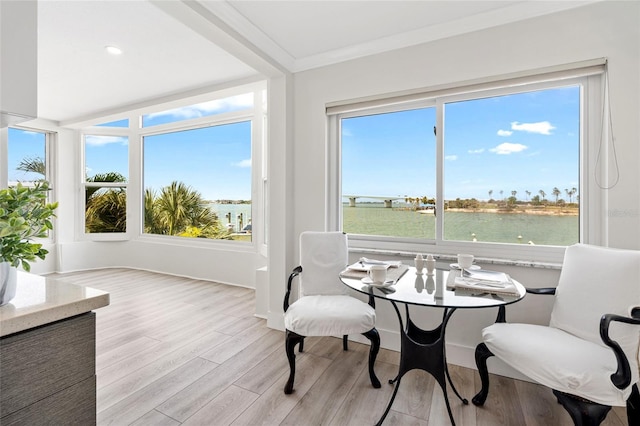 sunroom / solarium with plenty of natural light and a water view