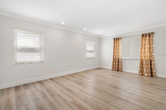spare room featuring crown molding, light wood-type flooring, baseboards, and recessed lighting