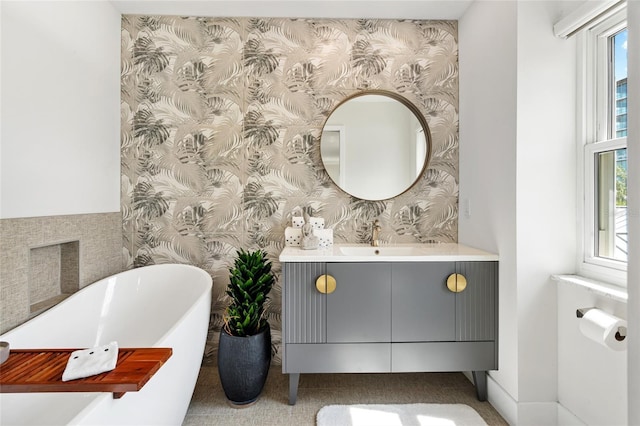 full bath featuring wallpapered walls, a soaking tub, plenty of natural light, and vanity