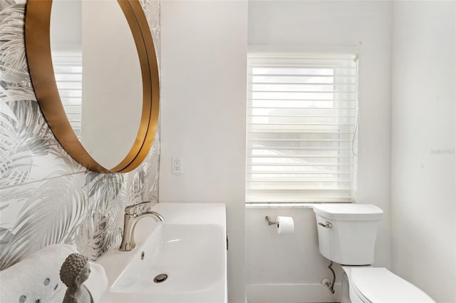 half bathroom featuring a sink and toilet