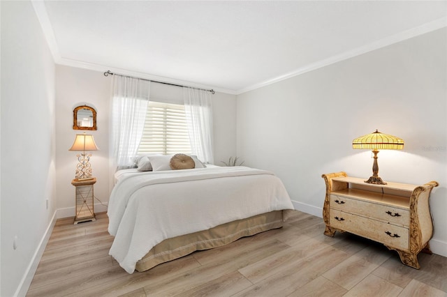 bedroom with crown molding, light wood-style flooring, and baseboards