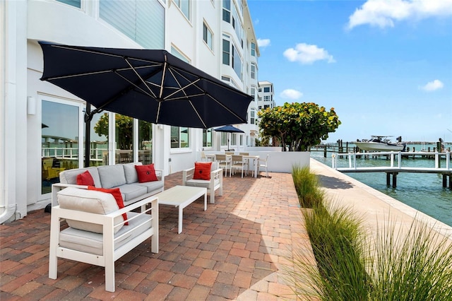view of patio featuring an outdoor hangout area, a water view, a dock, outdoor dining space, and boat lift