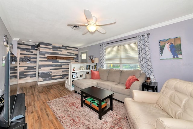 2004 19th St W, Bradenton, FL 34205 - living area with ornamental molding, an accent wall, wood finished floors, a ceiling fan, and baseboards