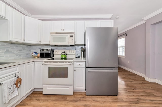 2004 19th St W, Bradenton, FL 34205 - kitchen with white appliances, ornamental molding, light wood-style flooring, white cabinets, and decorative backsplash