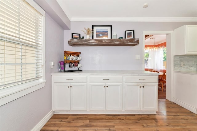 2004 19th St W, Bradenton, FL 34205 - indoor dry bar with light wood-style flooring, a chandelier, crown molding, tasteful backsplash, and baseboards