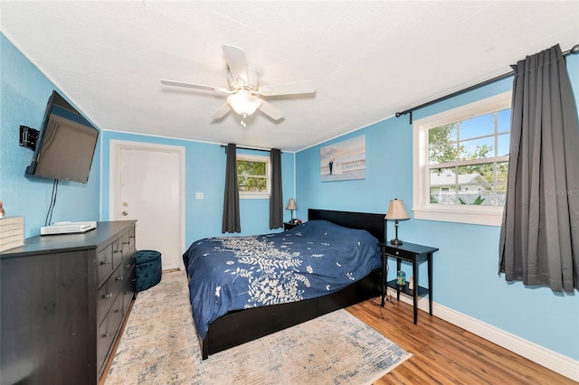 2004 19th St W, Bradenton, FL 34205 - bedroom with wood finished floors, baseboards, multiple windows, and a ceiling fan