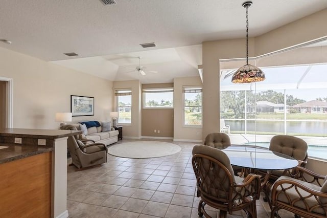 12007 Clubhouse Dr, Lakewood Ranch, FL 34202 - dining area featuring a ceiling fan, light tile patterned flooring, vaulted ceiling, baseboards, and a water view