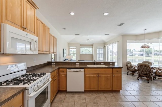 12007 Clubhouse Dr, Lakewood Ranch, FL 34202 - kitchen with white appliances, a sink, dark countertops, a peninsula, and recessed lighting