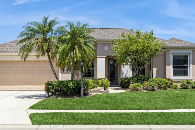 12007 Clubhouse Dr, Lakewood Ranch, FL 34202 - obstructed view of property featuring stucco siding, a garage, a front yard, concrete driveway, and a shingled roof