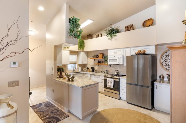 kitchen with stainless steel appliances, a sink, a peninsula, light tile patterned floors, and decorative backsplash