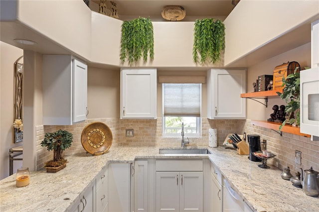 kitchen with a sink, open shelves, white cabinetry, and backsplash