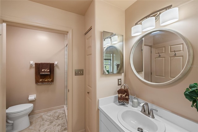 bathroom with vanity, toilet, and baseboards