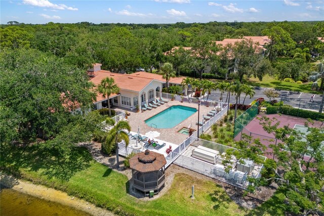 drone / aerial view of a pool and a forest