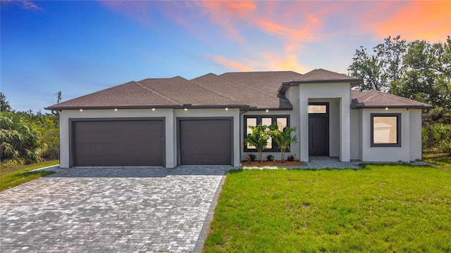 7152 Bougainvillea St, Englewood, FL 34224 - view of front of house with an attached garage, stucco siding, a yard, and decorative driveway
