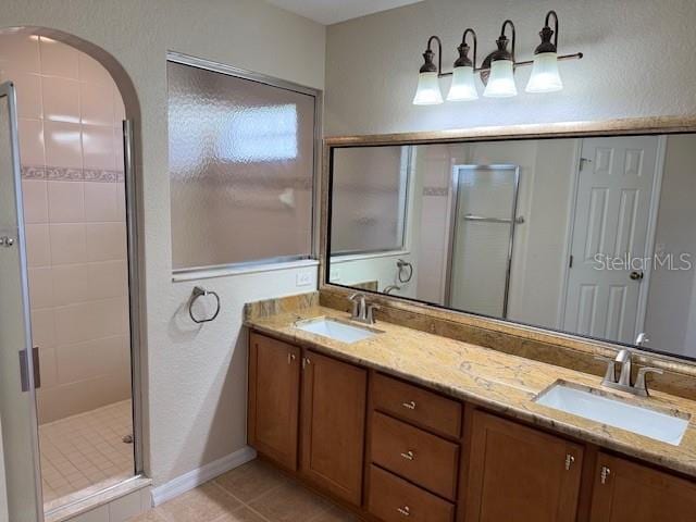 full bathroom with a stall shower, tile patterned floors, and double vanity