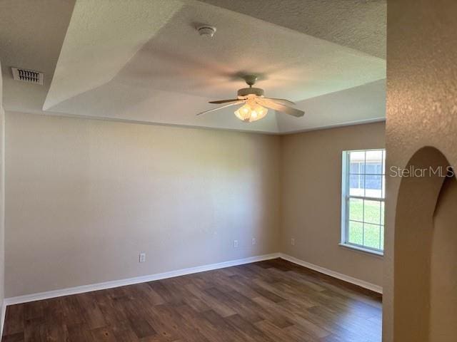spare room with dark wood-style floors, ceiling fan, baseboards, and a smoke detector