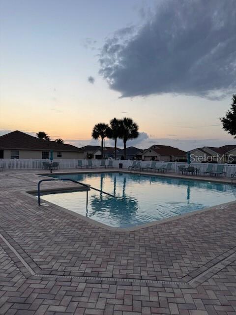 community pool featuring fence and a patio area