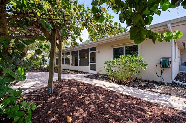 6512 Bowline Dr, Sarasota, FL 34231 - back of property featuring a sunroom, stucco siding, and a patio area