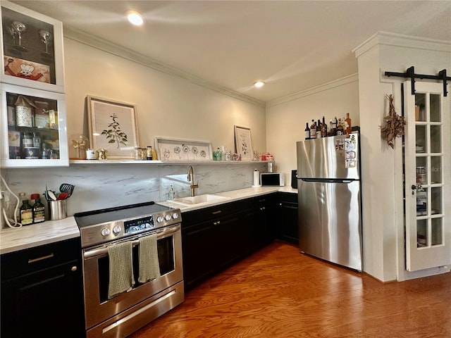 210 N 17th St W Unit 15, Bradenton, FL 34205 - kitchen featuring appliances with stainless steel finishes, a sink, dark cabinetry, crown molding, and light countertops