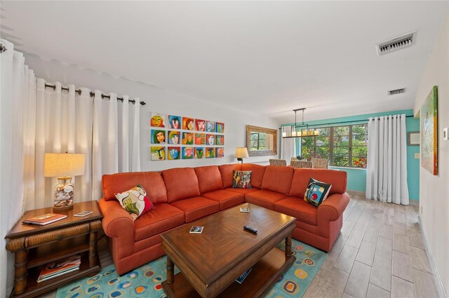 941 Virginia Dr, Sarasota, FL 34234 - living room with light wood finished floors, baseboards, and a chandelier