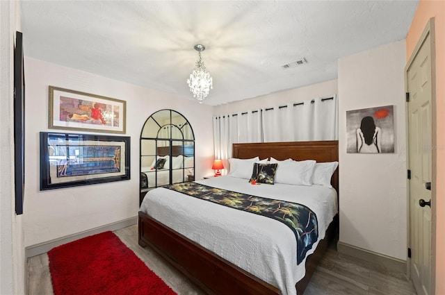 941 Virginia Dr, Sarasota, FL 34234 - bedroom with a chandelier, baseboards, and wood finished floors