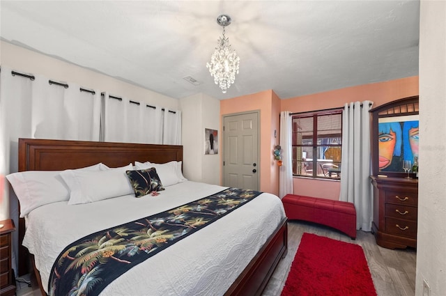 941 Virginia Dr, Sarasota, FL 34234 - bedroom featuring wood finished floors and a chandelier