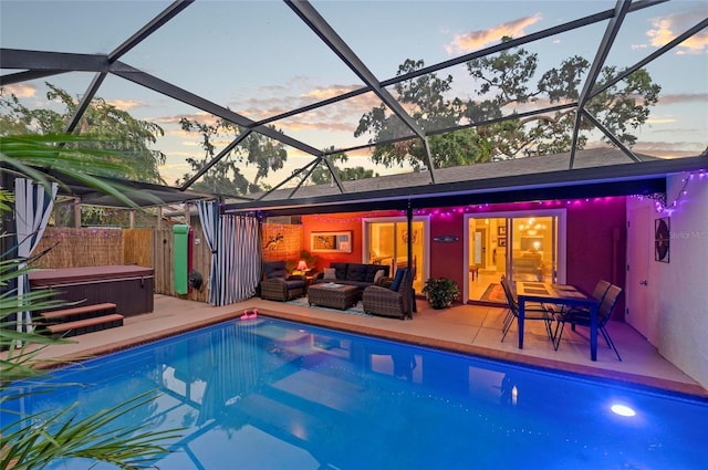 941 Virginia Dr, Sarasota, FL 34234 - pool at dusk with a hot tub, a patio area, an outdoor hangout area, and a lanai
