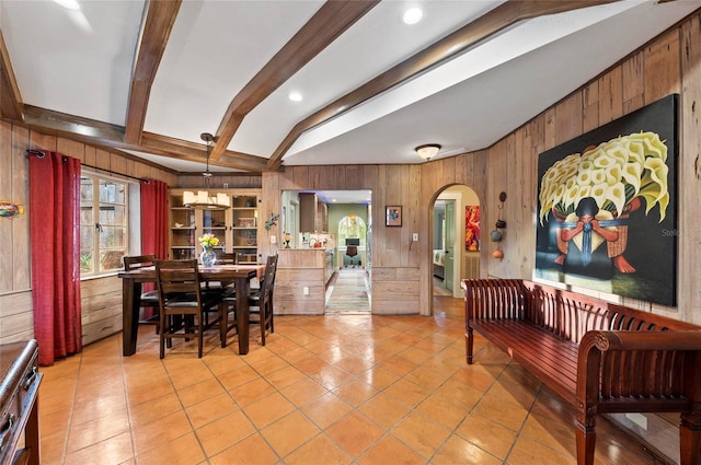 941 Virginia Dr, Sarasota, FL 34234 - dining room with arched walkways, wood walls, light tile patterned flooring, and beam ceiling