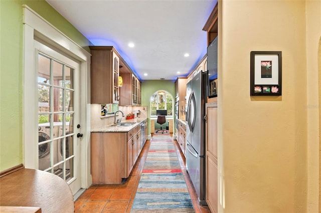 941 Virginia Dr, Sarasota, FL 34234 - kitchen with a sink, glass insert cabinets, light stone counters, recessed lighting, and stainless steel refrigerator with ice dispenser