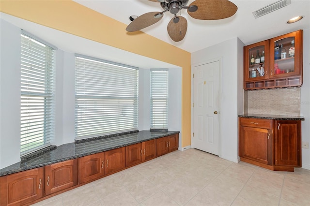 unfurnished dining area featuring plenty of natural light, a ceiling fan, and light tile patterned floors