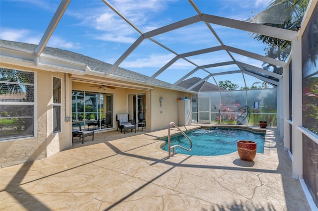 swimming pool with a patio, a ceiling fan, and glass enclosure
