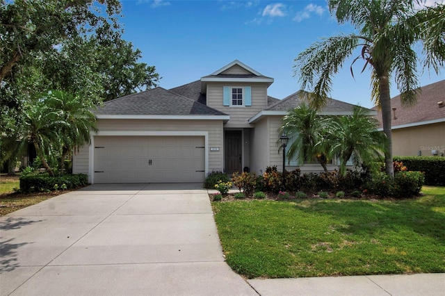 traditional home featuring a garage, a front yard, concrete driveway, and roof with shingles