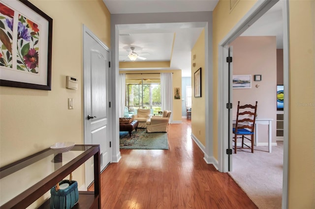 hall featuring wood finished floors and baseboards