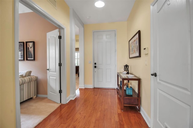 hall with baseboards and light wood-style floors