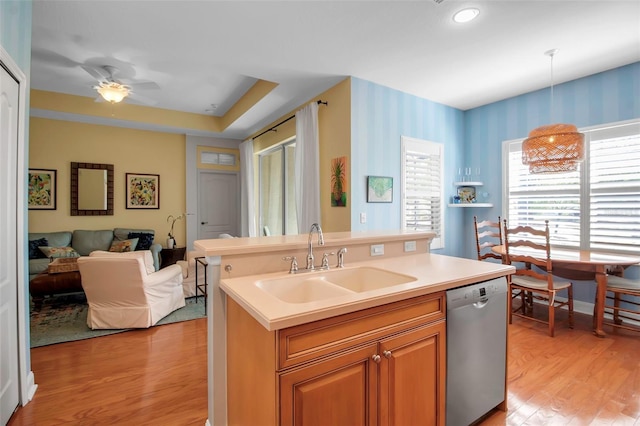 kitchen with dishwasher, light wood-type flooring, a sink, open floor plan, and wallpapered walls